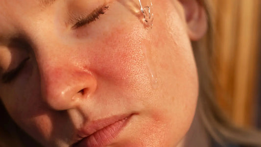 A stressed person looking in the mirror and touching their red, peeling skin, feeling frustrated by retinol burn.